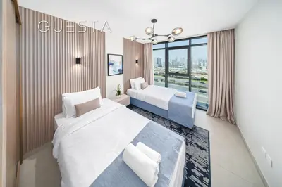 a hotel room with two beds and a window at Azizi Greenfield, Meydan Dubai in Dubai