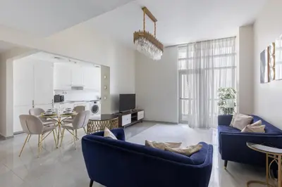 a living room with two blue couches and a table at Bright 2BR Marina View with Balcony in Dubai
