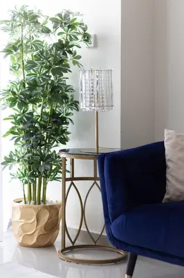 a living room with a blue couch and a table and a plant at Bright 2BR Marina View with Balcony in Dubai