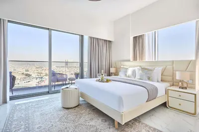 a bedroom with a large bed and large windows at Frank Porter - Adhara Star in Dubai