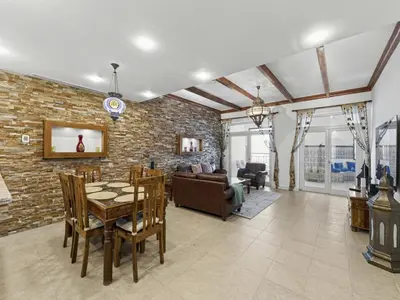 a living room with a table and a brick wall at DVH Al Basri Palm Beachfront 2BR Full Sea Views in Dubai