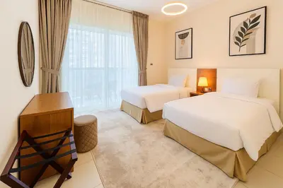 a hotel room with two beds and a window at Deluxe Apartments Near WTC and Sheikh Zayed in Dubai