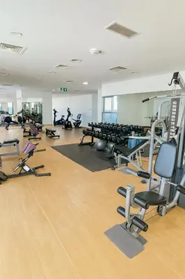 a gym with lots of treadmills and exercise bikes at Deluxe Apartments Near WTC and Sheikh Zayed in Dubai