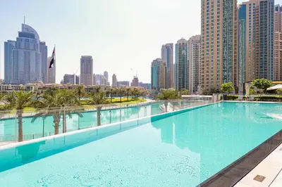 a large swimming pool with a city skyline in the background at Brand New 1BR - Burj View - Infinity Pool - Dubai Mall in Dubai
