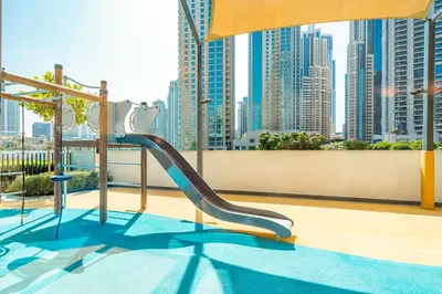 a slide in a pool with a view of a city at Brand New 1BR - Burj View - Infinity Pool - Dubai Mall in Dubai