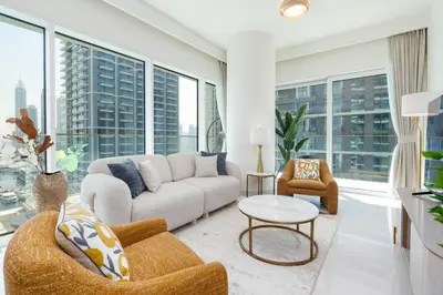 a living room with a couch and chairs and large windows at Beachfront Luxury 1BR with Private Beach, Marina & Sea Views in Dubai