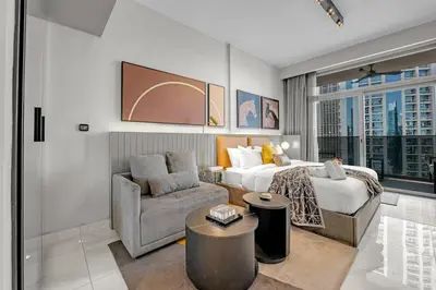 a hotel room with a bed and a chair at Chic Studio Steps to Dubai Mall with Infinity Pool in Dubai