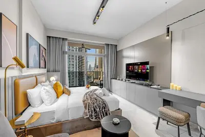 a bedroom with a large bed and a tv at Chic Studio Steps to Dubai Mall with Infinity Pool in Dubai