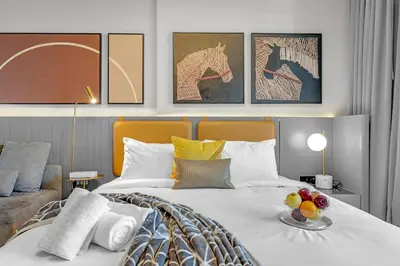 a bedroom with a bed with a plate of fruit on it at Chic Studio Steps to Dubai Mall with Infinity Pool in Dubai
