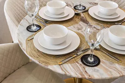 a table with plates and cups and wine glasses on it at Stylish 1-Bedroom Apartment in JVC Dubai in Dubai