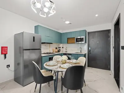 a kitchen with a table and chairs and a refrigerator at Opalz Serenity Designer- 1BDR Retreat-07 in Dubai