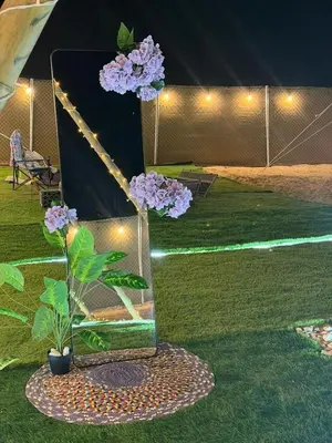 a vase with flowers in it on the grass at dubai camp in ‘Ūd al Bayḑāʼ