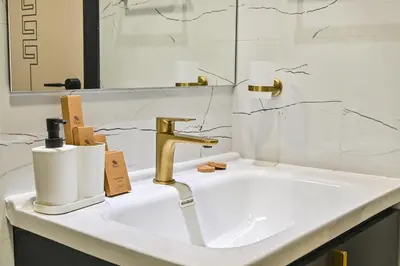 a bathroom with a sink with a gold faucet at Luxury studio Near Miracle Garden with Gym & Pool in Dubai