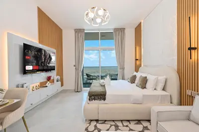 a bedroom with a bed and a large window at Luxury studio Near Miracle Garden with Gym & Pool in Dubai
