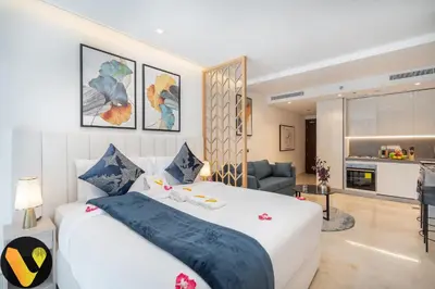a bedroom with a large bed and a living room at Vogue Downtown The Sterling by Omniyat, near Burj Khalifa and Dubai Mall, Studio Apartment with Balcony and Access to all Amenities in Dubai