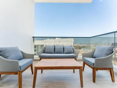 a living room with a couch and two chairs at Sway Retreat 1BR Apartment with Burj Khalifa View in Dubai