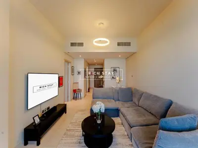 a living room with a couch and a flat screen tv at Sway Retreat 1BR Apartment with Burj Khalifa View in Dubai