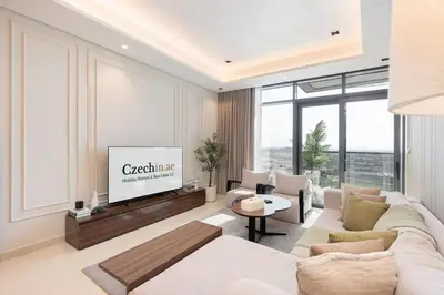 a living room with a couch and a tv at Comfortable 2BR Near Downtown by Czechin in Dubai
