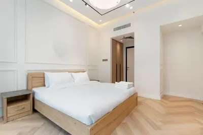a white bedroom with a large bed and a skylight at Burj Khalifa View 5 Min walk to Dubai Mall in Dubai