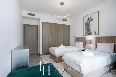 a bedroom with two beds and a chandelier at LUX The Dubai Marina Skyline Suite 2 in Dubai