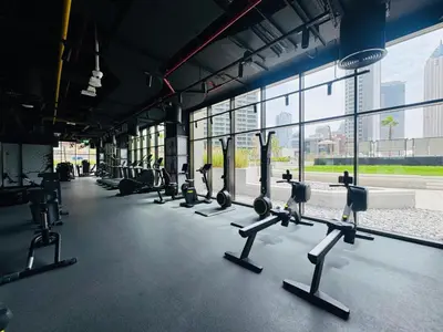 a gym with rows of exercise equipment in a building at Curated High-Floor 1BR Water View Peninsula 1 in Dubai