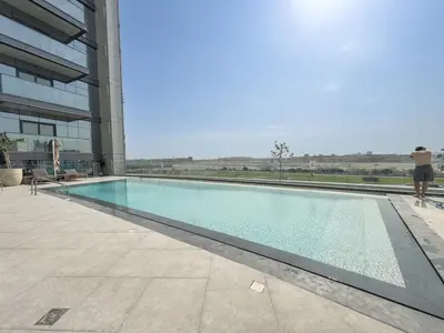 a person standing next to a swimming pool in a building at Luxury 2BR Nobles Tower Business Bay by Czechin in Dubai