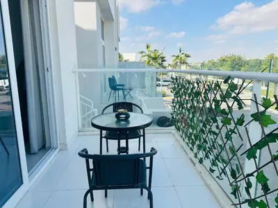 two chairs and a table on a balcony at 1 BR luxury flat Damac hills2 in ‘Ūd al Bayḑāʼ