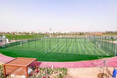 a large soccer field with a soccer goal at 1 BR luxury flat Damac hills2 in ‘Ūd al Bayḑāʼ