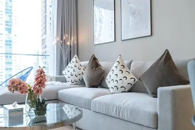 a living room with a white couch and a glass table at Vogue Marina Gate near JBR Beach and Marina Mall, One Bedroom Apartment with Balcony and city skyline view, Access to all Amenities in Dubai