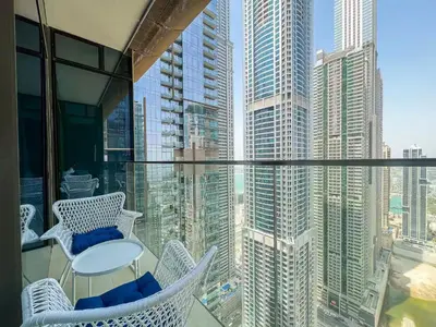 a balcony with chairs and a view of a city at Vogue Marina Gate near JBR Beach and Marina Mall, One Bedroom Apartment with Balcony and city skyline view, Access to all Amenities in Dubai