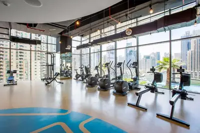 a gym with treadmills and exercise equipment in a building at Vogue Marina Gate near JBR Beach and Marina Mall, One Bedroom Apartment with Balcony and city skyline view, Access to all Amenities in Dubai