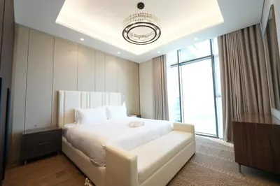 a bedroom with a white bed and a large window at Well-Designed Modern 2 BHK Apartment Nobles Tower in Dubai