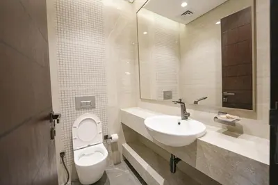 a bathroom with a white toilet and a sink at Well-Designed Modern 2 BHK Apartment Nobles Tower in Dubai