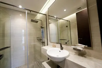 a bathroom with a sink and a glass shower at Well-Designed Modern 2 BHK Apartment Nobles Tower in Dubai