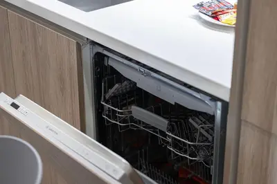 a dishwasher in a kitchen with its door open at High Rise Premium 2BR apt, PS5, Burj Khalifa view. in Dubai
