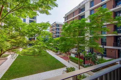an apartment balcony with trees and a yard at Vacationer l Vibrant 2 Bed l Dubai Hills Mall l Free Pool, Gym in Dubai