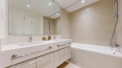 a bathroom with two sinks and a tub and a mirror at Vacationer l Vibrant 2 Bed l Dubai Hills Mall l Free Pool, Gym in Dubai