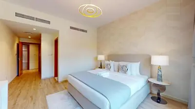 a bedroom with a large bed and a lamp at Vacationer l Peaceful 2 Bed l Sheikh Zayed Road l The Greens in Dubai
