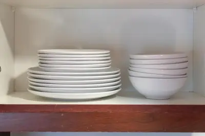 two stacks of plates and bowls sitting on a shelf at Pool View 2BR with Big Balcony in Dubai