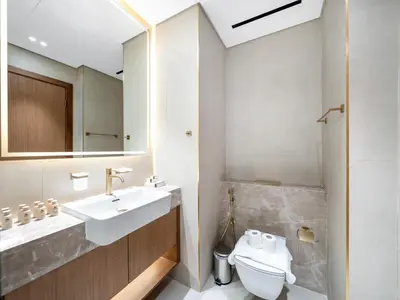 a bathroom with a sink and a toilet and a mirror at Spacious Studio with Balcony & Jacuzzi Trillionaire Residences, Business Bay in Dubai