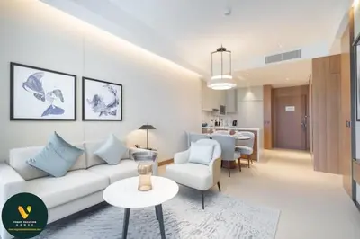 a living room with a white couch and a table at Vogue Downtown Address Residence near Burj Khalifa and Dubai Mall, Two Bedroom Apartment with Balcony and Burj Khalifa view, Access to all Amenities in Dubai