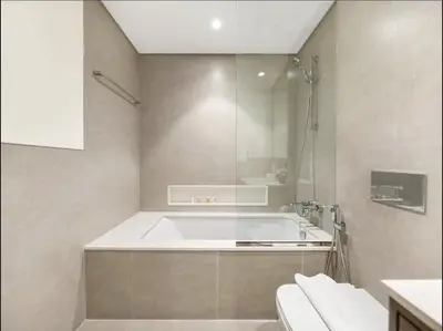 a bathroom with a bath tub and a shower at Upscale Burj Vista Downtown Stays with Burj Khalifa View in Dubai