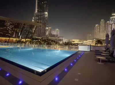 a swimming pool with a city skyline at night at Upscale Burj Vista Downtown Stays with Burj Khalifa View in Dubai