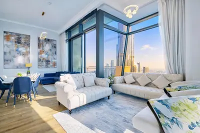 a living room with white furniture and a large window at Elite Burj Vista Downtown Dubai Apartments with Burj Khalifa View in Dubai