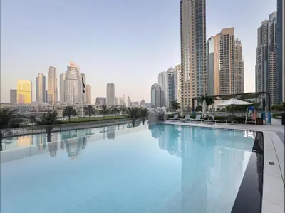 a large swimming pool in a city with tall buildings at Elite Burj Vista Downtown Dubai Apartments with Burj Khalifa View in Dubai