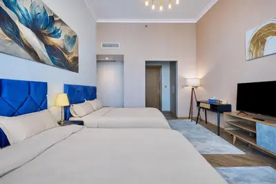 a hotel room with two beds and a flat screen tv at Elite Burj Vista Downtown Dubai Apartments with Burj Khalifa View in Dubai