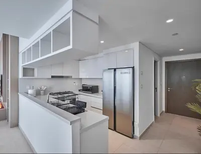 a kitchen with white cabinets and a stainless steel refrigerator at Premium Burj Vista Downtown Apartments with Burj Khalifa View in Dubai