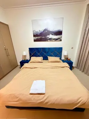 a large bed with a blue headboard in a room at Burj Khalifa View Apartments, Burj Vista Tower - Downtown in Dubai
