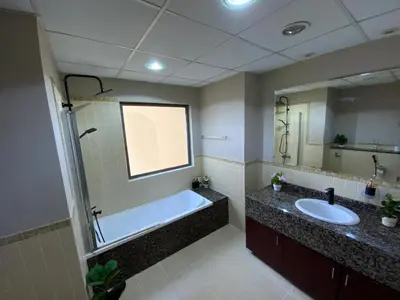 a bathroom with a tub and a sink and a mirror at palm tree Jbr in Dubai