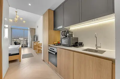 a kitchen with a sink and a microwave at Waves - Boho Style Chic Studio With Balcony in JVC in Dubai